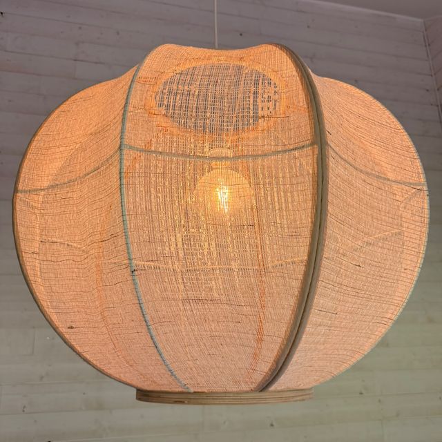 Ronde stoffen hanglamp geïnstalleerd in een slaapkamer